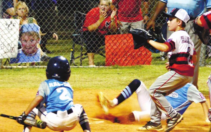 Putnam’s Bennett Haley is safe at home plate as teammate Hayden Harper (2) cheers him on.
