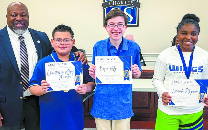 Superintendent Derick Austin presents certificates to students of the month (from left) Christopher Morales, Bryan Kelly and Larriah Pettigrew. CONTRIBUTED