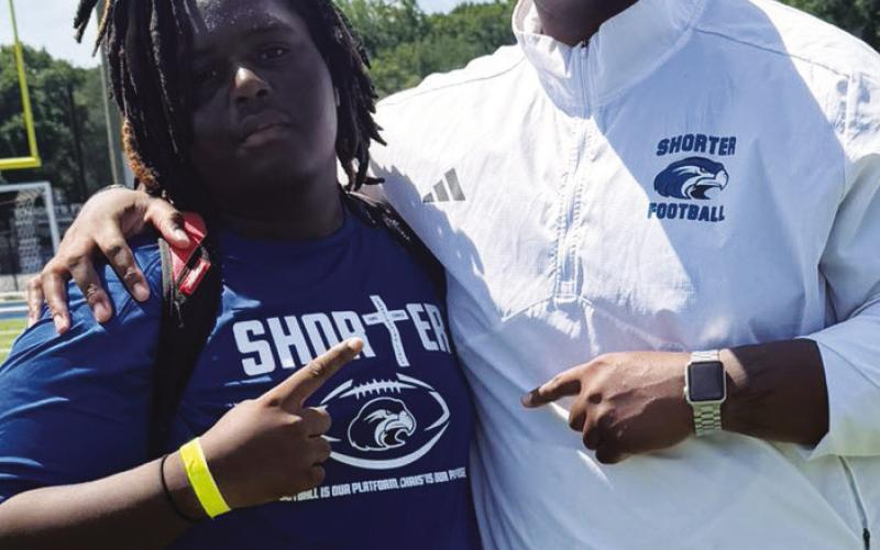 Putnam County offensive lineman Jabius Farley (left) with a Shorter University coach last month. CONTRIBUTED