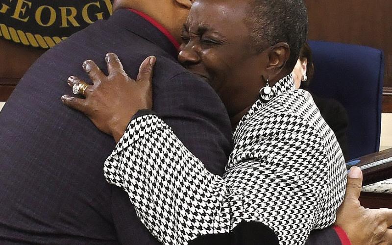 Eatonton Mayor John Reid hugs his wife, Janie, at the close of her outgoing city council meeting on Monday night. IAN TOCHER/Staff