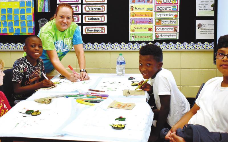 Busy painting their rocks are Logan Thomas, Noah Brown, Micah Treadwell, and Joseph Ruiz under the guidance of camp instructor Candace Wooten. LENA HENSLEY/Staff