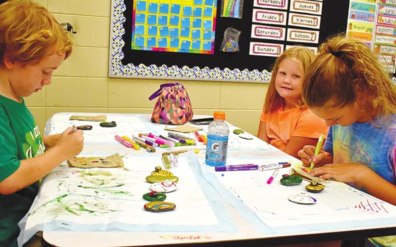 Gus Esau, Ava Kate Pope, and Charlie Cummings are absorbed in the creative process. LENA HENSLEY/Staff