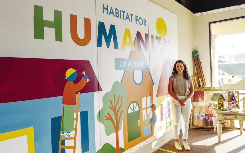 Morgan’s mural at Habitat for Humanity’s Re-Store in Putnam County. The mural features three individuals building homes. COURTESY OF GCSU