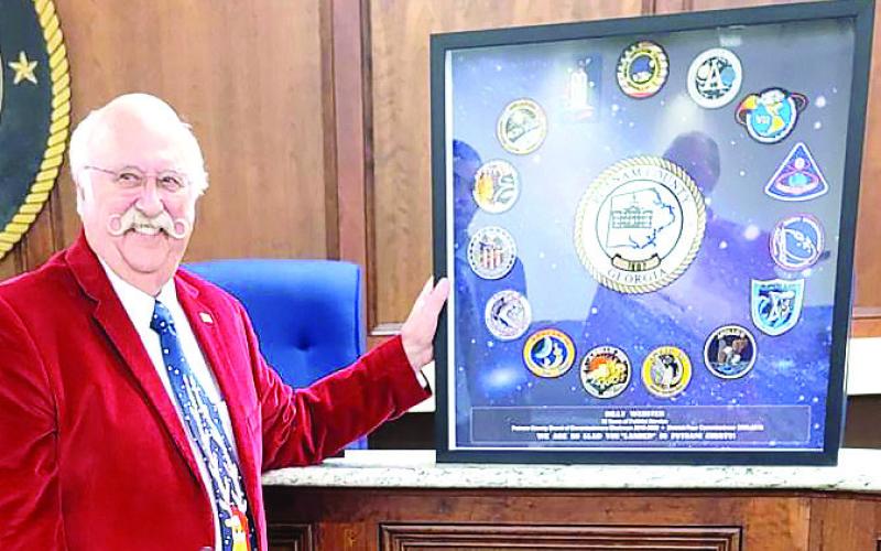 Billy Webster holds a framed montage of 13 shoulder patches from NASA’s Apollo program presented to him as a gift for his service as chairman. CONTRIBUTED