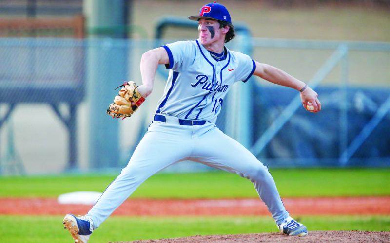 Putnam County senior pitcher Ethan Whatley (12) gets set to deliver a pitch during a recent road game against Athens Academy. LANCE McCURLEY/Staff