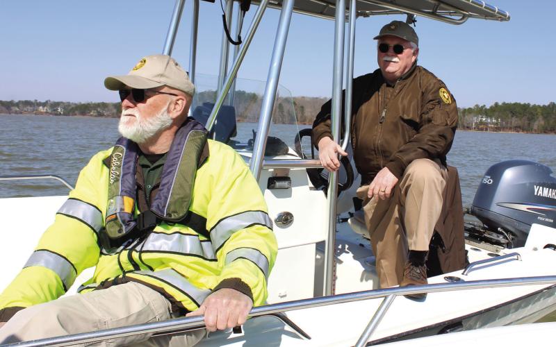 Putnam County Sheriff Howard Sills pilots a patrol boat Saturday, while Detective J.D. Turk closely watches the water on Lake Oconee in search of presumed drowned victim Gary Jones. CONTRIBUTED