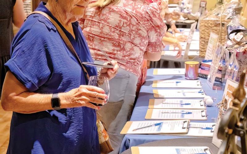 The silent auction item tables were kept busy throughout the evening LEIGH LOFGREN/Staff