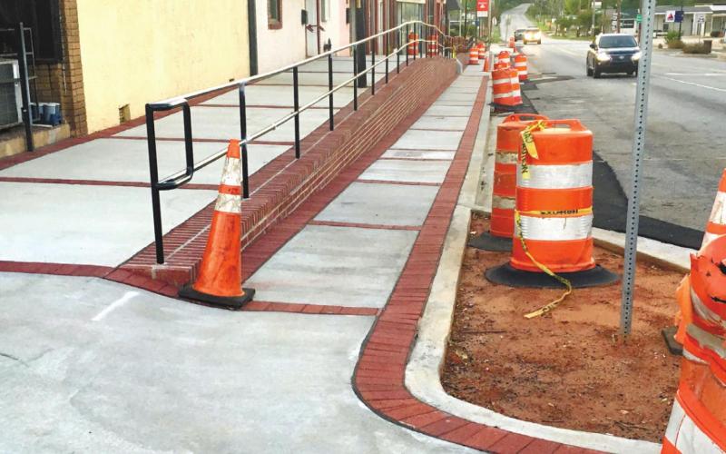 The sidewalk on North Jefferson that has been an embarrassing eyesore for two years looks complete except for the orange barrels, yellow tape and no landscaping. MARK ENGEL/Staff