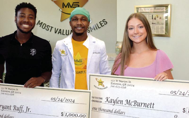 Recent Putnam County High School graduates Bryant Ruff Jr. (far left) and Kaylen McBurnett (far right) $1,000 scholarships from Most Valuable Smiles Dentistry in downtown Eatonton. (IAN TOCHER/Staff)