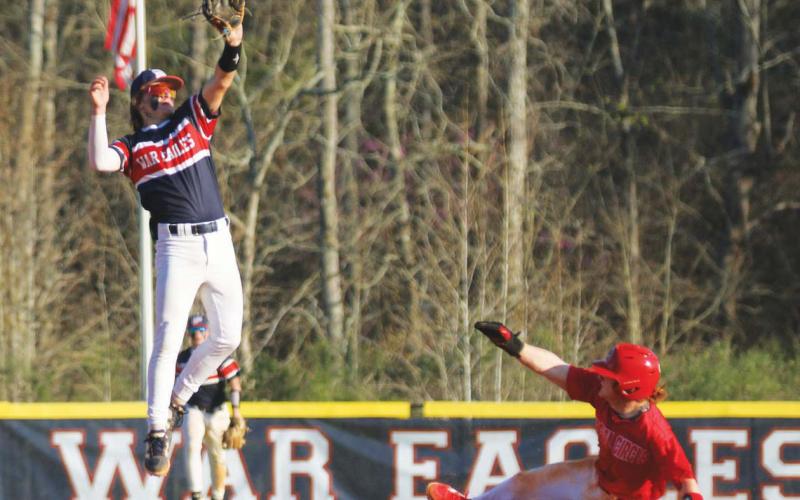 Putnam County’s Gates Lanzarone attempts to catch a ball in mid-air as a Social Circle player slides into second base safely. TREY NORRIS/Staff