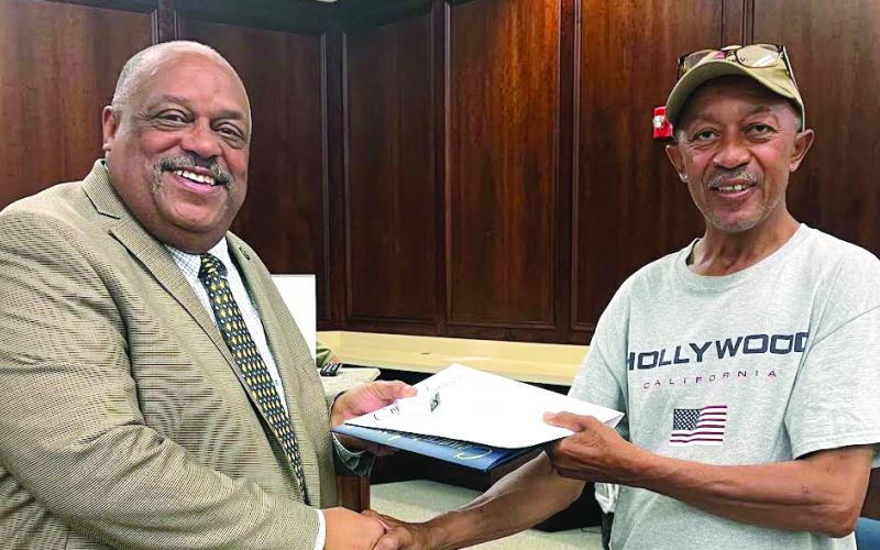 Kevin “Jack” Reid (right) of the Eatonton Streets Department received 10-years’ service recognition from Mayor John Reid. Afterward, Jack Reid told city council, “Y’all don’t know how much I appreciate working with y’all, working with the community … the best thing that ever happened to me was when I came to the city.” (IAN TOCHER/Staff)