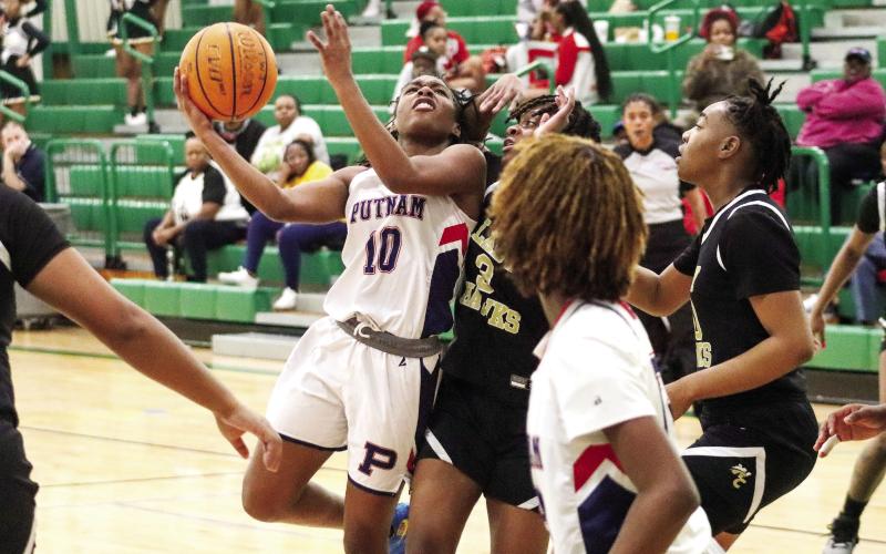 Putnam County freshman Journey Waller (10) tries to go up for a contested layup over a Washington County defender last week. LANCE McCURLEY/Staff