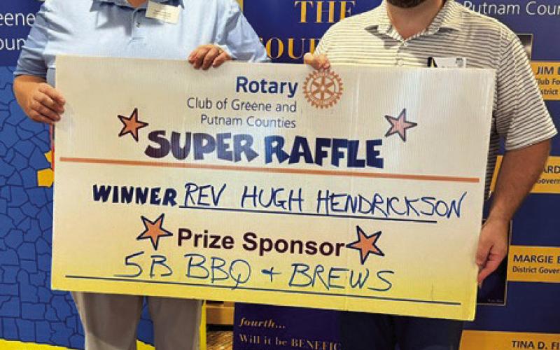 Rev. Hugh Hendrickson (left), winner of a $300 gift card from prize sponsor 5B Barbecue &amp;amp; Brews, Greensboro, accepts his prize from Rotarian Will Haley. The raffle prize sponsor was not available for the photo. CONTRIBUTED