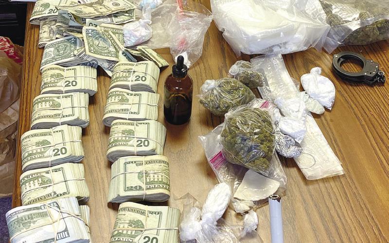 Bags of marijuana, cocaine, ecstasy pills, oxycodone, stacks of cash, and other items seized during a drugdealing arrest are spread out on a desk at Putnam County Sheri_’s Oce. CONTRIBUTED