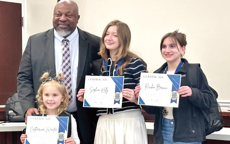 PCCSS Superintendent Derrick Austin (left) presented school bags and certificates to Putnam County students receiving Superintendent Student of the Month Awards for February (l-r): Catherine Wooten, Sophia Kelly, and Rivka Brown. ALIVIA BLANTON/Staff