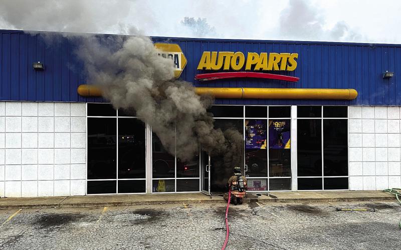 Smoke billows out as Eatonton Fire Department firefighter approaches the door of the NAPA Auto Parts store Nov. 19. COURTESY OF EATONTON FIRE DEPARTMENT