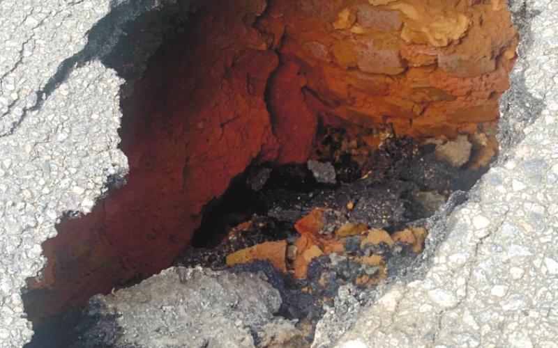 A small sinkhole at a sewer line in the middle of a downtown road is the cause of the intersection being closed several days. CONTRIBUTED