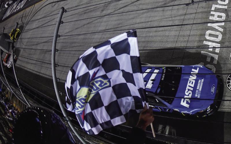 Chris Buescher, driver of the #17 Fastenal Ford, takes the checkered flag to win the Bass Pro Shop Night Race at Bristol Motor Speedway Saturday. (Logan Riely/Getty Images)
