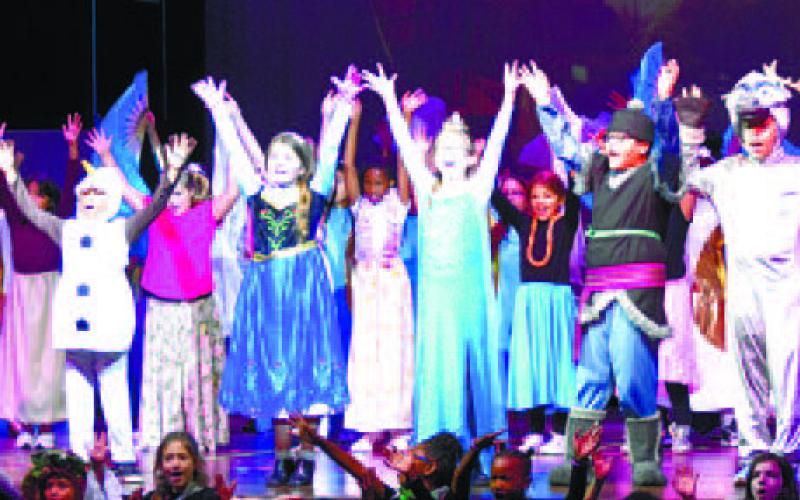 At the finale of the show, the students raise hands as they sing the final song. LENA HENSLEY/Staff