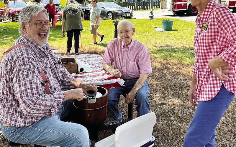 Rufus Adair, Tom Rosseter, and Mary Air churn ice cream on the Plaza's lawn. (EMMA CLAUSE/Staff)