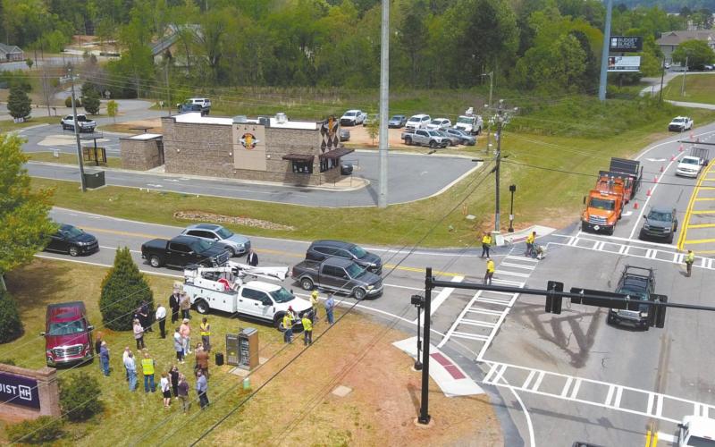 Workmen finish up painting lines at the intersection of Ga. Highway 44 (Lake Oconee Parkway) and Scott Road in north Putnam County. After 11 years of planning, a new traffic light was activated at the intersection Tuesday, allowing residents and travelers to avoid collisions when turning left. MARK ENGEL/Staff