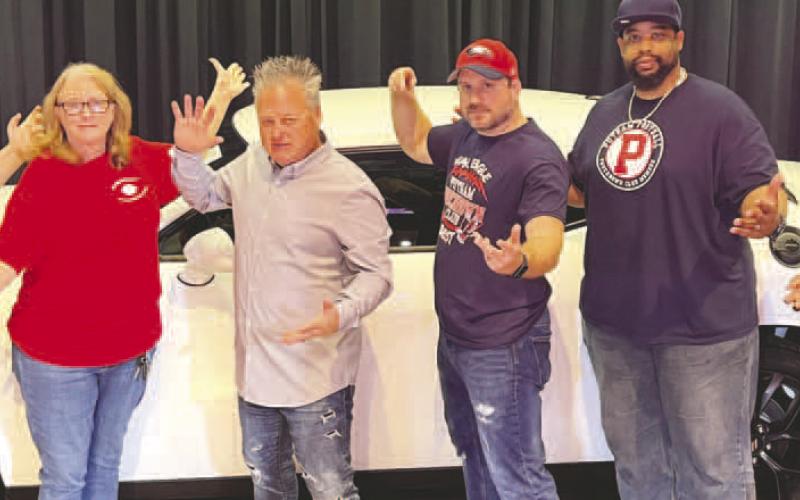Mark the Magic Man (4th from left) poses with members of the Putnam County Touchdown Club at the end of his family show Saturday afternoon. IAN TOCHER/Staff