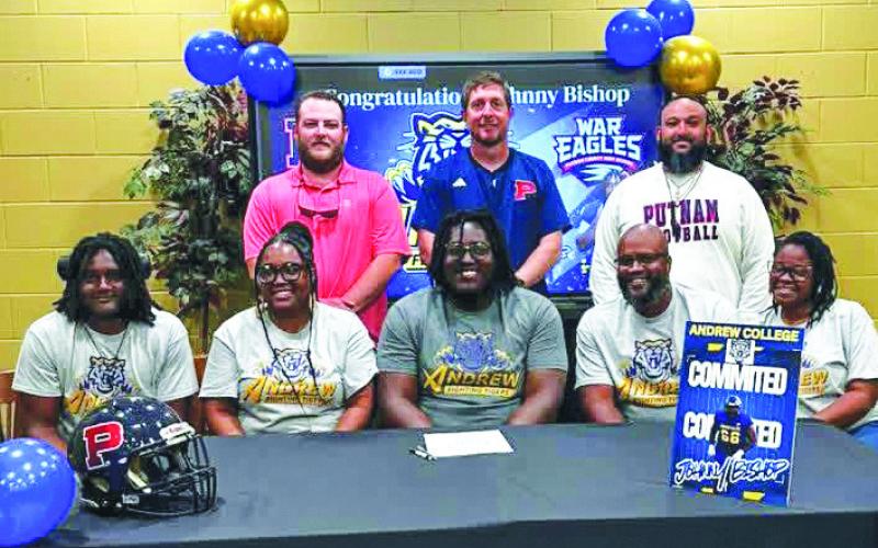 Surrounded by his family and with his coaches standing behind him, Putnam County’s Johnny Bishop (center) recently signed a commitment to attend and play football for Andrew College this fall. CONTRIBUTED