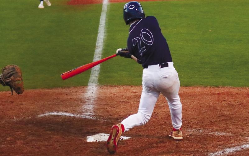 Putnam County senior Jacob Grimes (20) smacks a single to right field Feb. 27, in a loss to Athens Academy. LANCE MCCURLEY/Staff