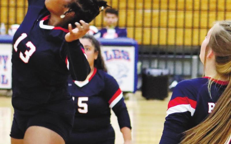 Senior Tytianna Little at the net with Lacey Bruce (7) and Angelica Alexander (15).