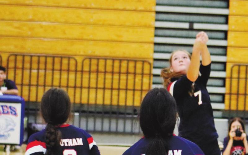 Lacey Bruce gets the ball over net with Leslye Arriolla (9) and Regina Espin (12).