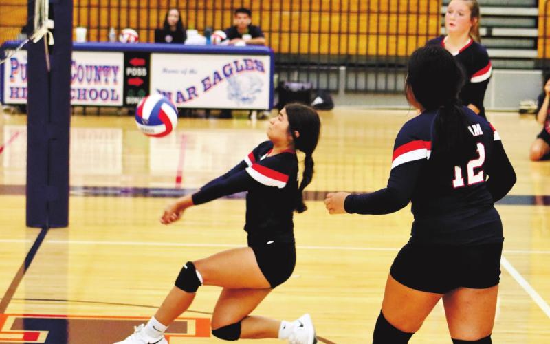 Leslye Arriola with the big dig surround by Regina Espin (12) and Lacey Bruce (7).