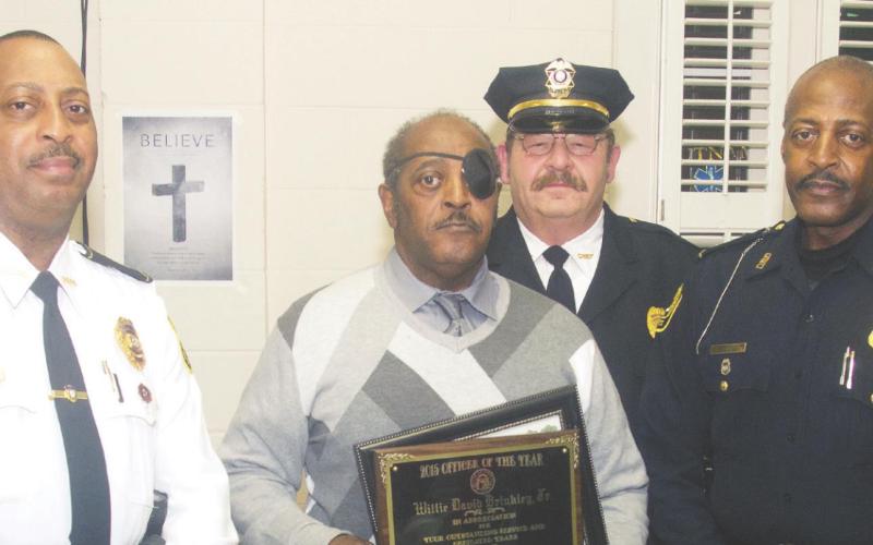 Eatonton Police officer Willie Brinkley Jr. holds two plaques he received – the MAC’s Employee of the Year award and he Eatonton Police Department Employee of the Year award – at a Mothers Against Crime annual holiday awards banquet in 2015. He is flanked by his brother, Leon Brinkley, a retired Georgia State University police officer, and his son, Willie Brinkley III, an Athens-Clarke County police officer. Behind them is then-Eatonton Police Chief Kent Lawrence. FILE PHOTO