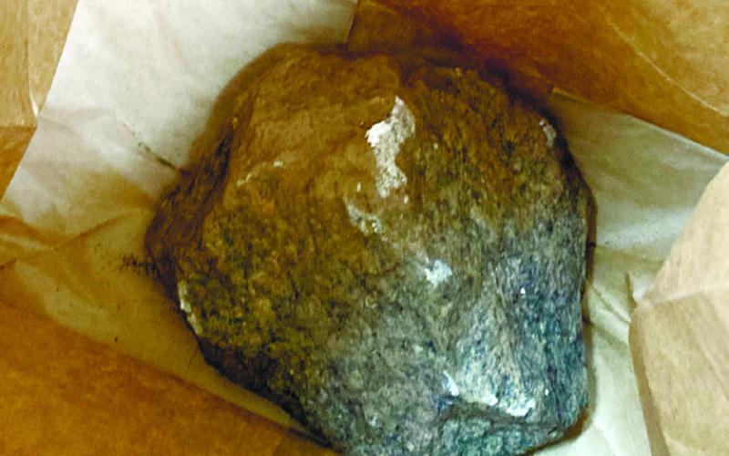 A large rock believed to be used to shatter glass doors at Jimmy Davis Park, is held in an evidence bag at Putnam County Sheriff’s Office. LYNN HOBBS/ Staff
