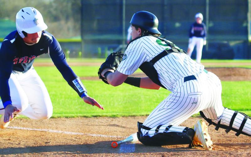 Gatewood catcher Connor Mitchem blocks a Strong Rock runner at the plate in the Gators’ season opener last week in Eatonton. TREY NORRIS/Staff