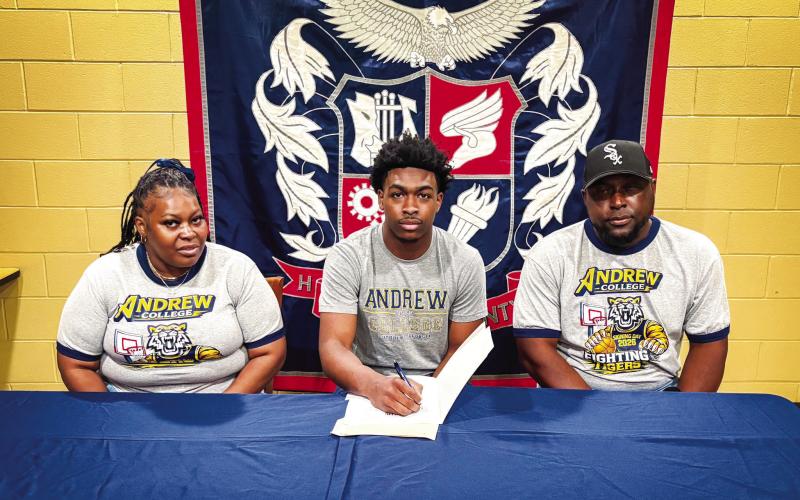 Putnam County boys basketball senior Jmari Greene (center) recently signed a letter of intent to play for Andrew College. CONTRIBUTED