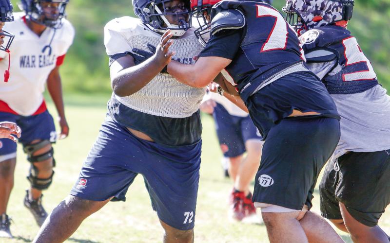 A Putnam County defensive lineman (72) goes up against an offensive lineman from Winder-Barrow during a padded camp held in Eatonton on July 17. LANCE McCURLEY/Staff