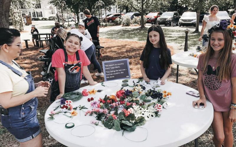 Children enjoy making flower crowns at the May Day event. CONTRIBUTED