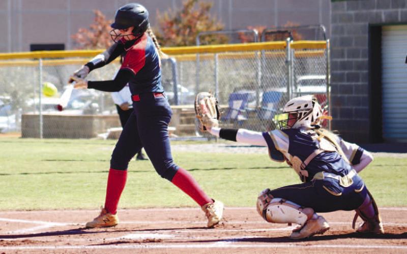 Sam Spisak swings and connects with her homerun hit.