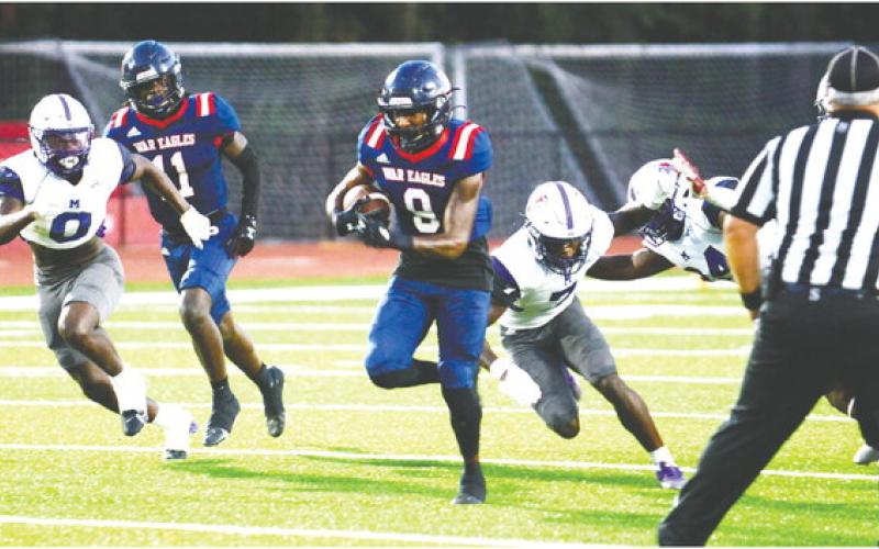 Kaleb Crawford (9) runs past Jasper County defenders in Friday’s 24-17 win. IAN TOCHER/Staff
