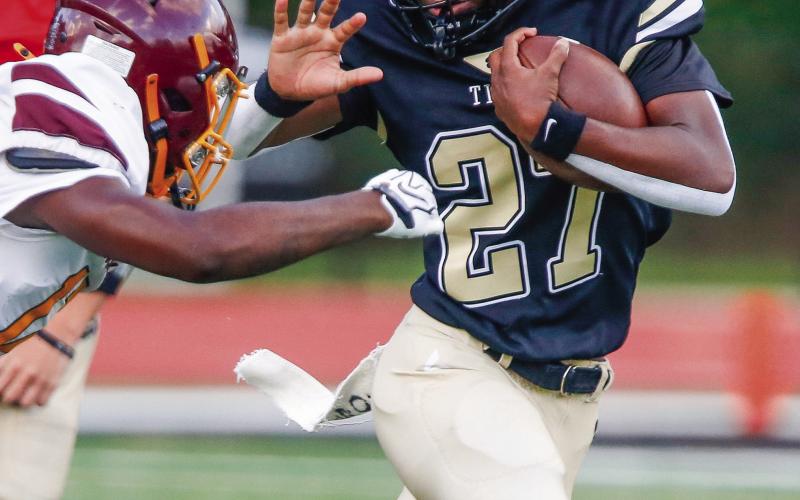 Greene County running back Johnathan Lawrence (27) prepares to stiff-arm a Hancock Central defender during a scrimmage. LANCE McCURLEY/Staff