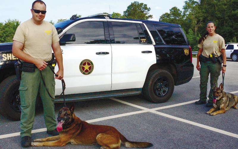 Putnam County Sheriff’s Deputies Chris Donovan and Holly Collins are inseparable from their K-9 partners Nix (left) and Cora. IAN TOCHER/Staff