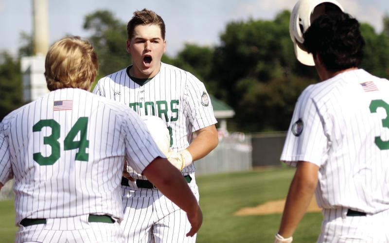 Gatewood’s Lawson Moore takes off his helmet and celebrates with teammates after hitting of his two home runs against Trinity Christian. TREY NORRIS/Staff