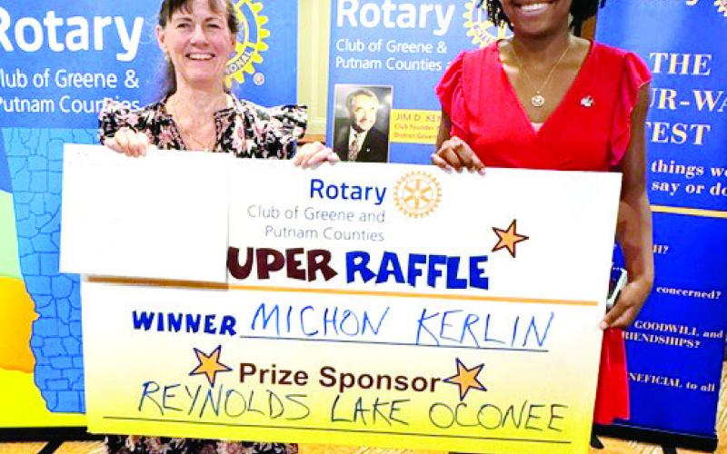 Rotary Raffle Week 31 winner Michon Kerlin (left) accepts her prize from Rotarian Destiny McClendon. Sponsored by Reynolds Lake Oconee (not available for the photo), Kerlin won a gift certificate for a round of golf for four and dinner for two at the National Tavern, including a preselected bottle of wine, representing a $1,550 total prize value. CONTRIBUTED