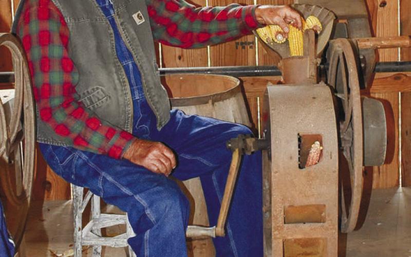Stepback owner and creator Calvin Taylor demonstrates the operation of a corn husker powered by the watermill.