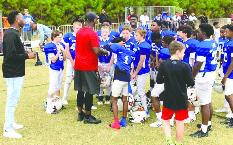 Putnam County High School varsity football assistant coach Kedric Manning talks to a group of youth football players last season. CONTRIBUTED