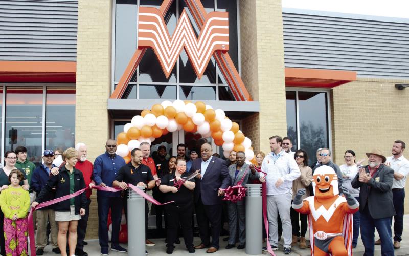 Taylor Borders and her daughter, Autumn (far left), were the first in line on the sidewalk at Whataburger for the ribboncutting ceremony, which earned Borders free weekly Whataburger meals for a year. IAN TOCHER/Staff