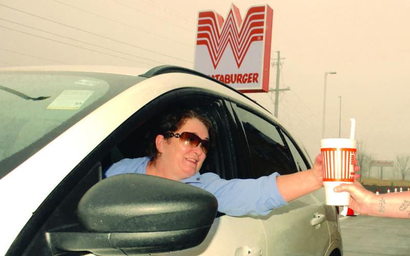Trudi Harwood of Madison picked up free Whataburger meals for a year just by driving one of the first two cars through the pick-up lane. IAN TOCHER/Staff