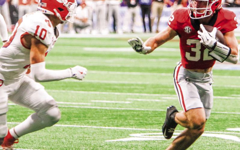 Georgia running back Cash Jones stiff arms a Clemson defender on his way to the end zone. (LANCE McCURLEY/Staff)