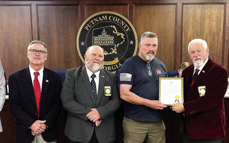 L-R: Newly elected District 1 Commissioner Tom McElhenney, District 2 Commissioner Daniel Brown, Commissioner Jeff Wooten of District 4, retiring Putnam County Fire Department Battalion Chief Michael Alford, County Chairman Bill Sharp, and District 3 Commissioner Dr. Steve Hersey stepped forward for Alford’s retirement recognition. IAN TOCHER/Staff