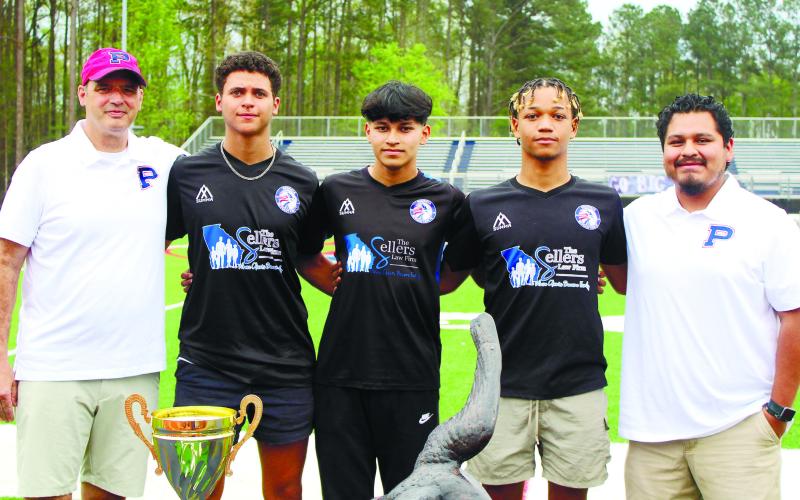 Putnam County head coach Michael Taylor (far left) poses with seniors (from left to right) Brad Reeves, Edwith Lopez and Marco Owensby, with assistant coach Jared Coronado (far right), after the players signed scholarships to play at the collegiate level. ARELLA CASH/Staff
